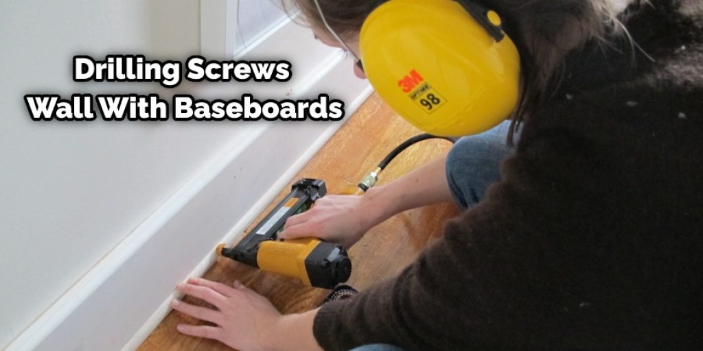Drilling Screws Wall With Baseboards