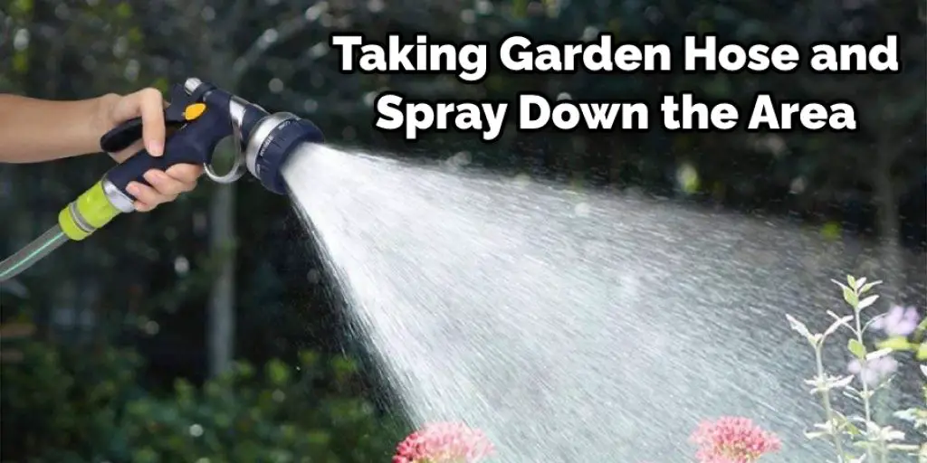 Taking Garden Hose and Spray Down the Area